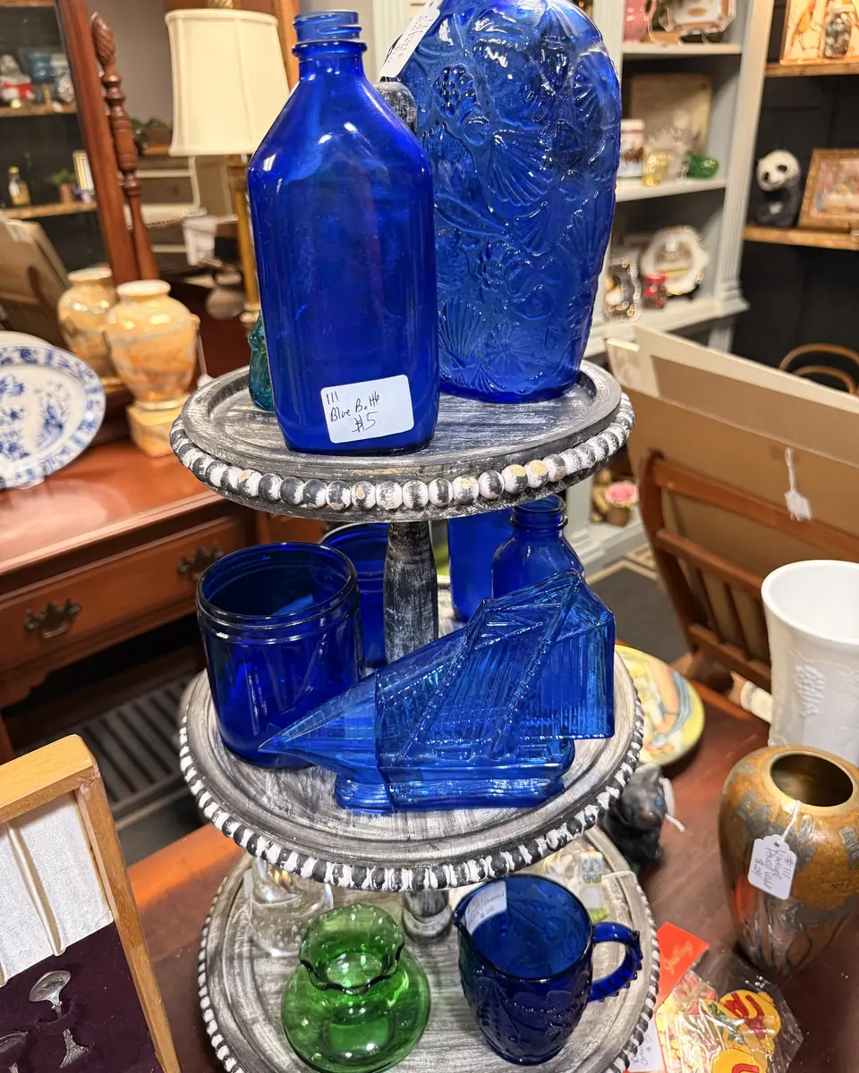 Cobalt-blue glass bottles, bowls, and small vessels grouped on display at Vintage 72
