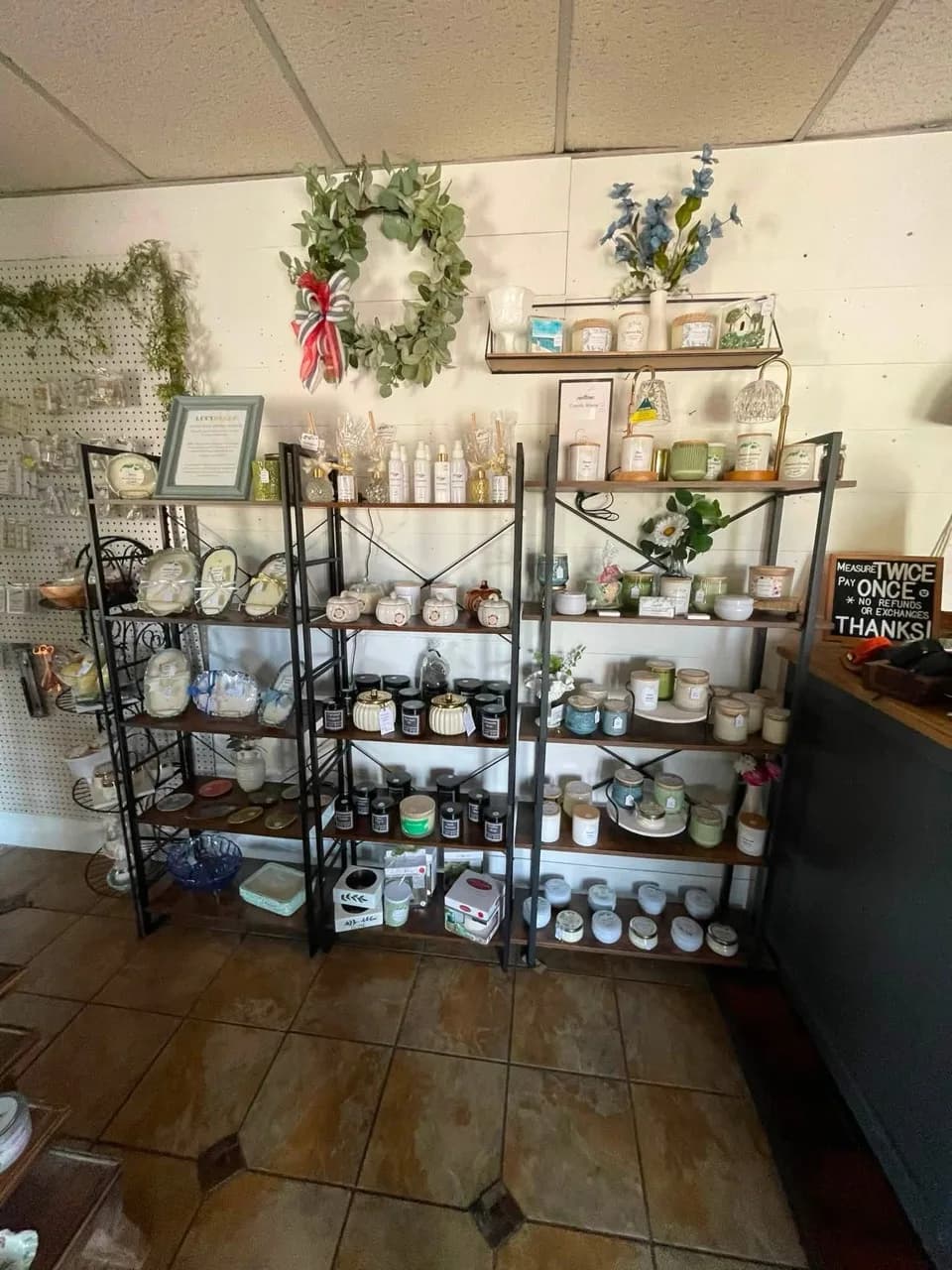Vendor booth stocked with hand-poured candles, bath goods, and gift items