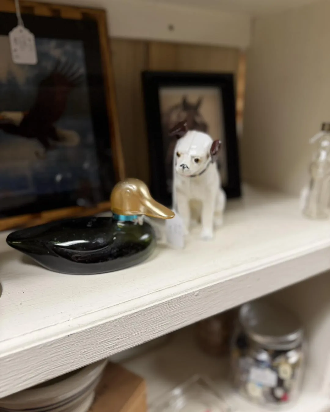 Duck decoy, bulldog figurine, and small collectibles on display