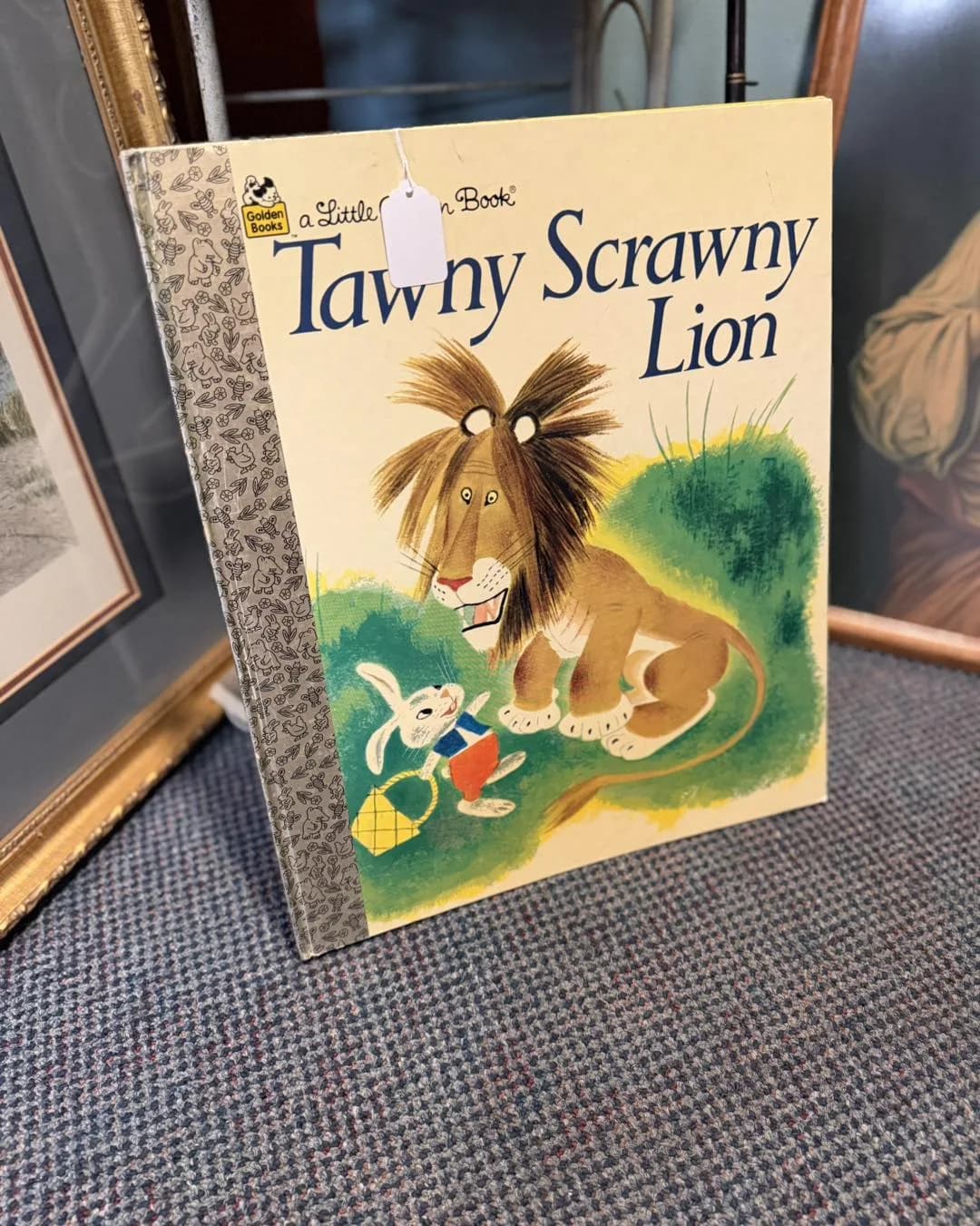 Golden book and tawny lion figurine among vintage smalls
