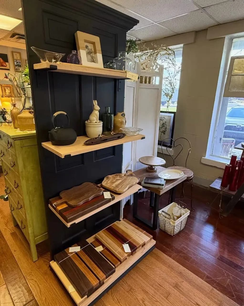 Handcrafted cutting boards and pottery arranged on a black display wall