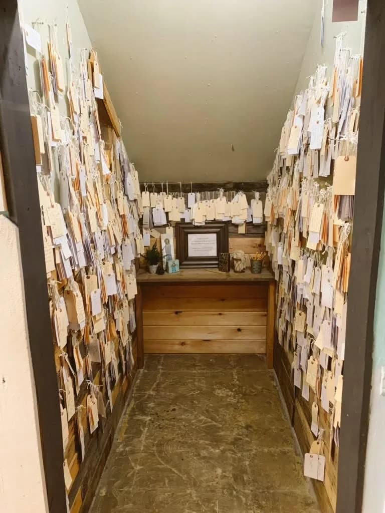 Walls covered with handwritten vendor tags inside a cozy shop nook