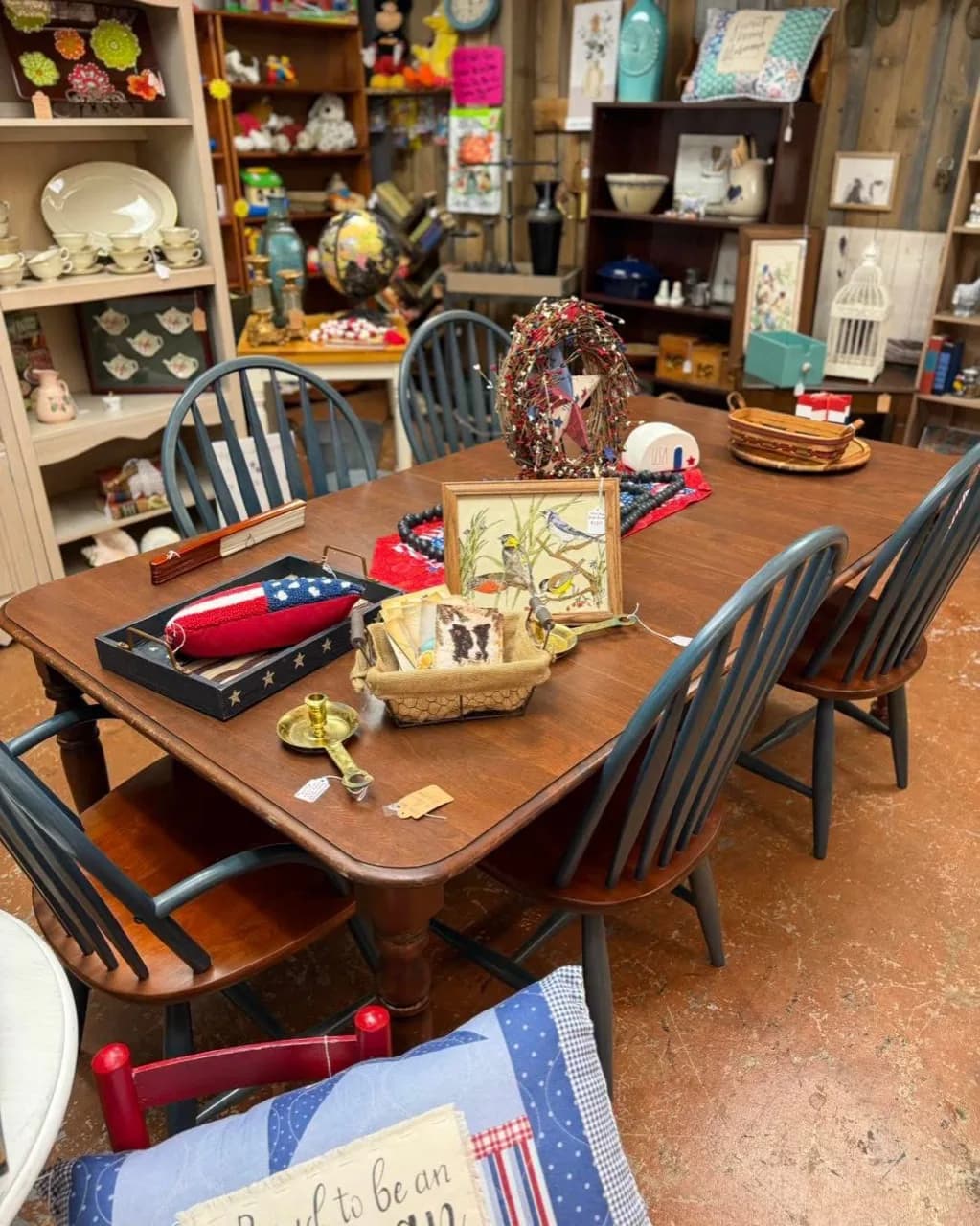 Wood dining table and spindle-back chairs surrounded by vintage decor