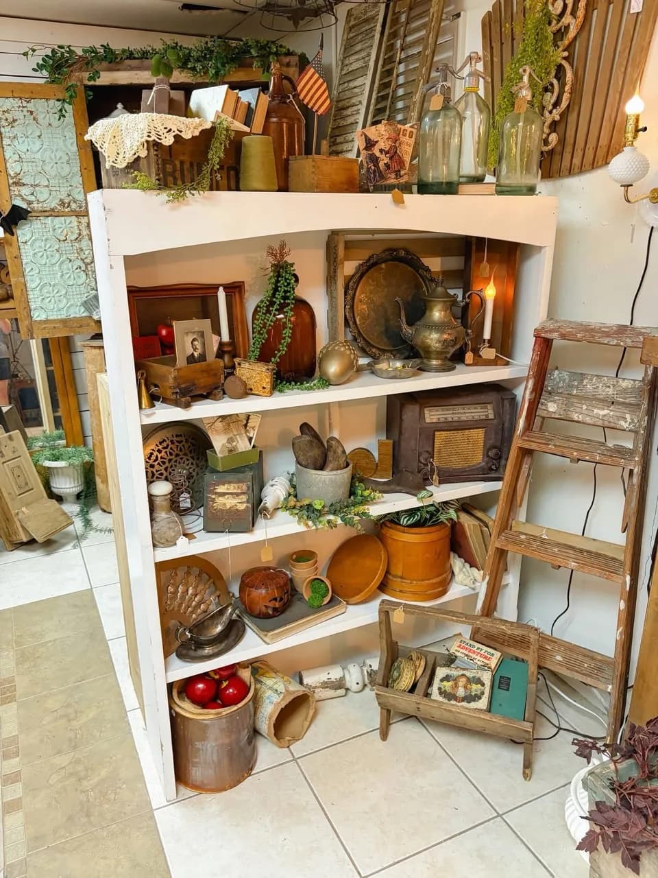 Olde South shelves filled with vintage bottles, silver serving pieces, an old radio, and collected antiques