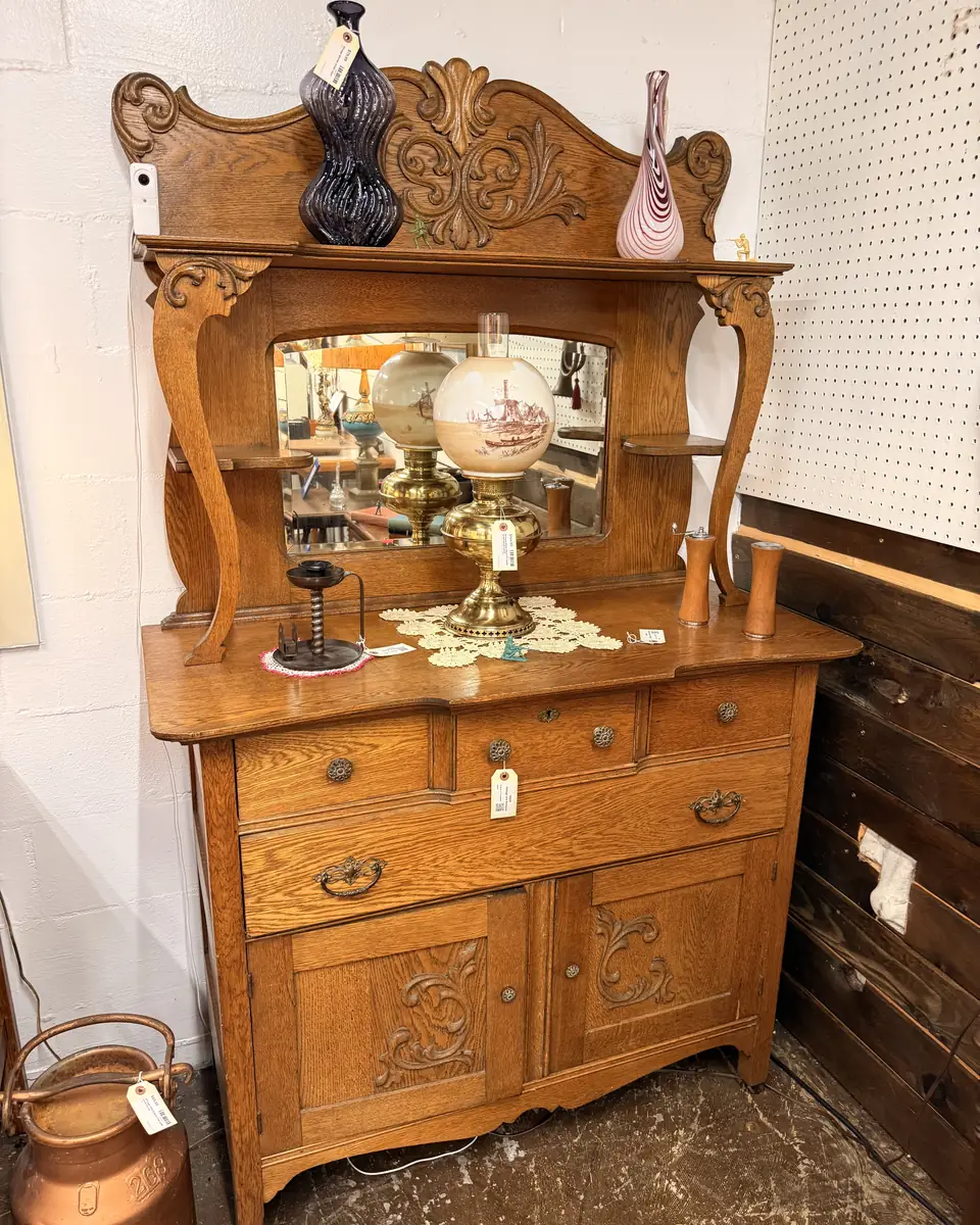 Carved cabinet with low mirrored back, drawers, and lower doors at Vintage 72