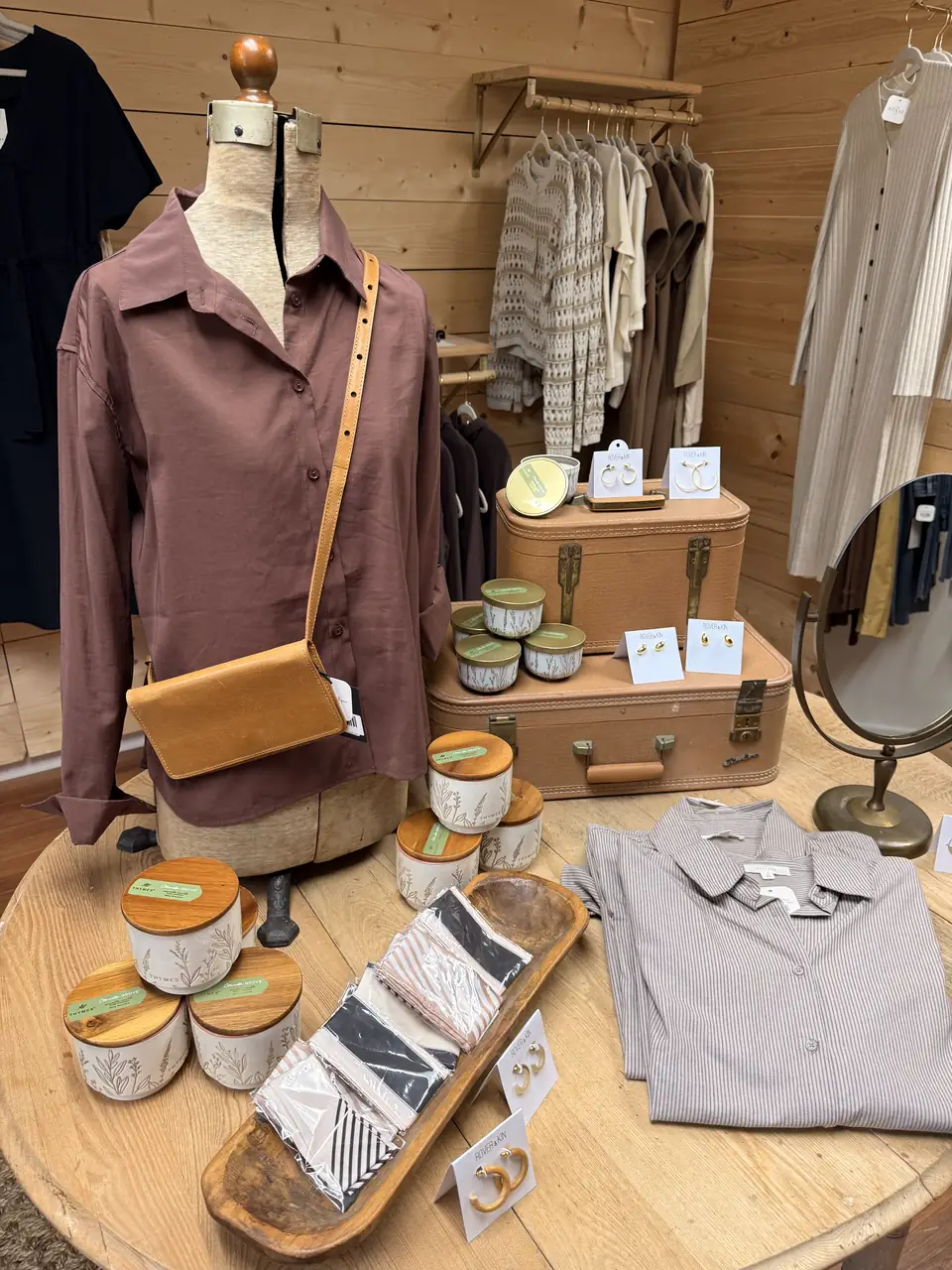 Clothing, jewelry, candles, and neutral accessories displayed in the upstairs boutique room at Vintage 72