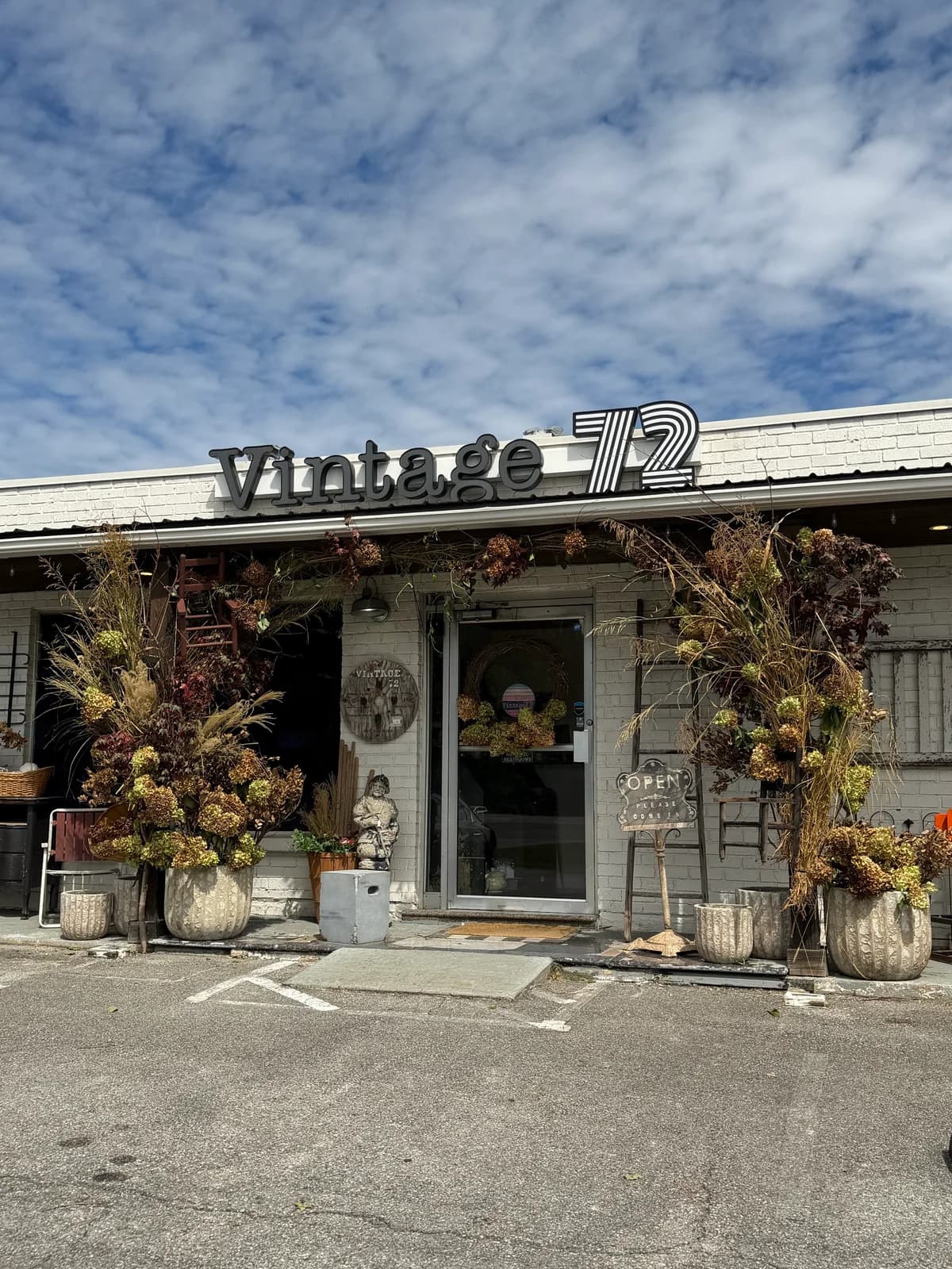 Fall foliage and planters framing the entrance beneath the Vintage 72 sign