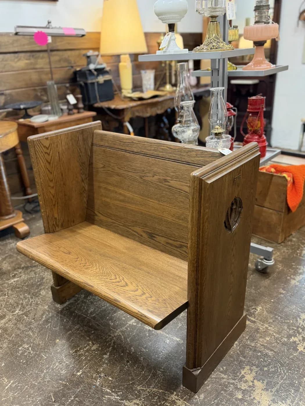 Vintage wooden preacher / deacon bench with a plank back, wide seat, and decorative cutout in the right side, displayed at Vintage 72.